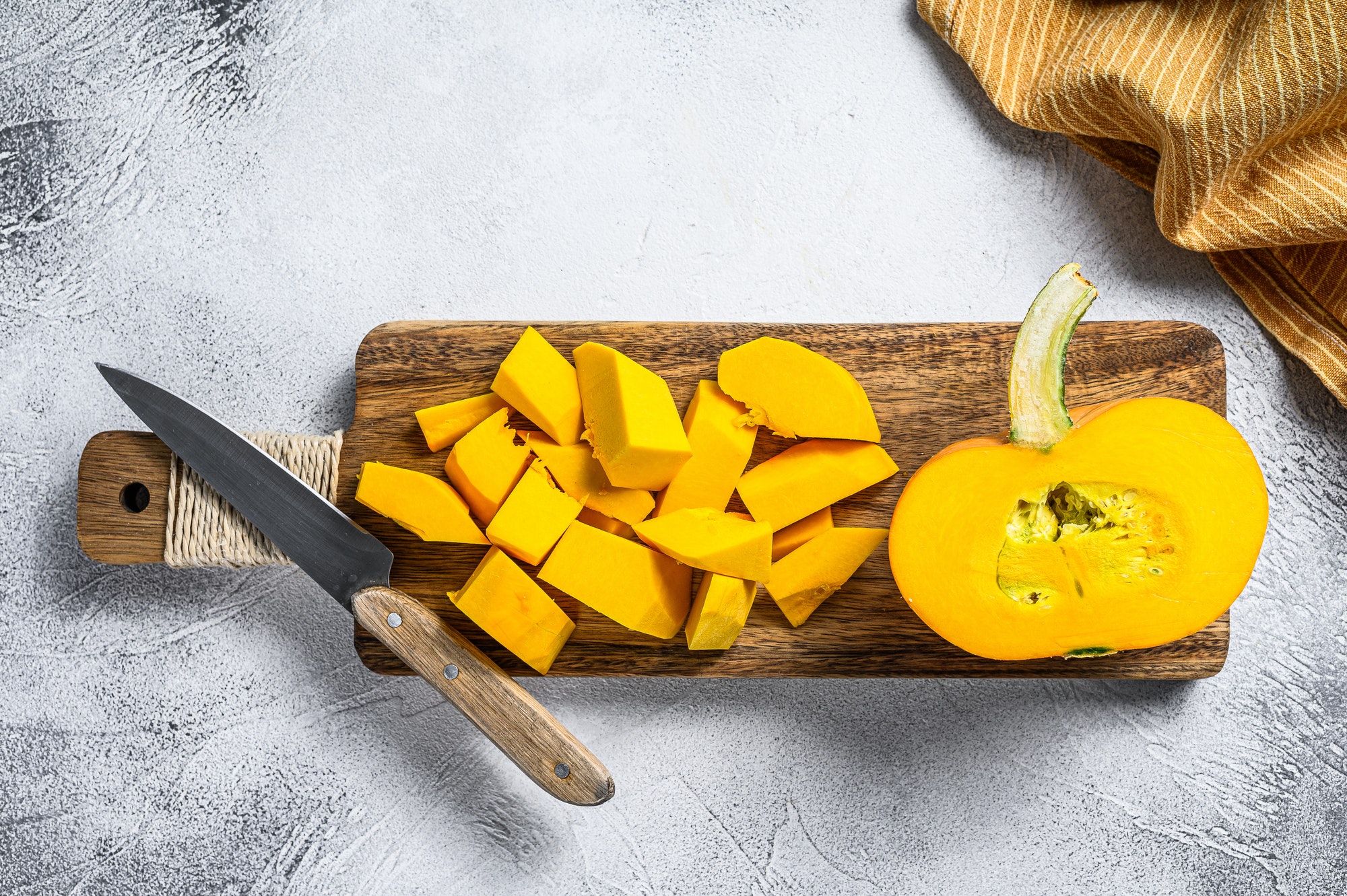 Sliced raw orange pumpkin on a chopping Board. White background. Top view